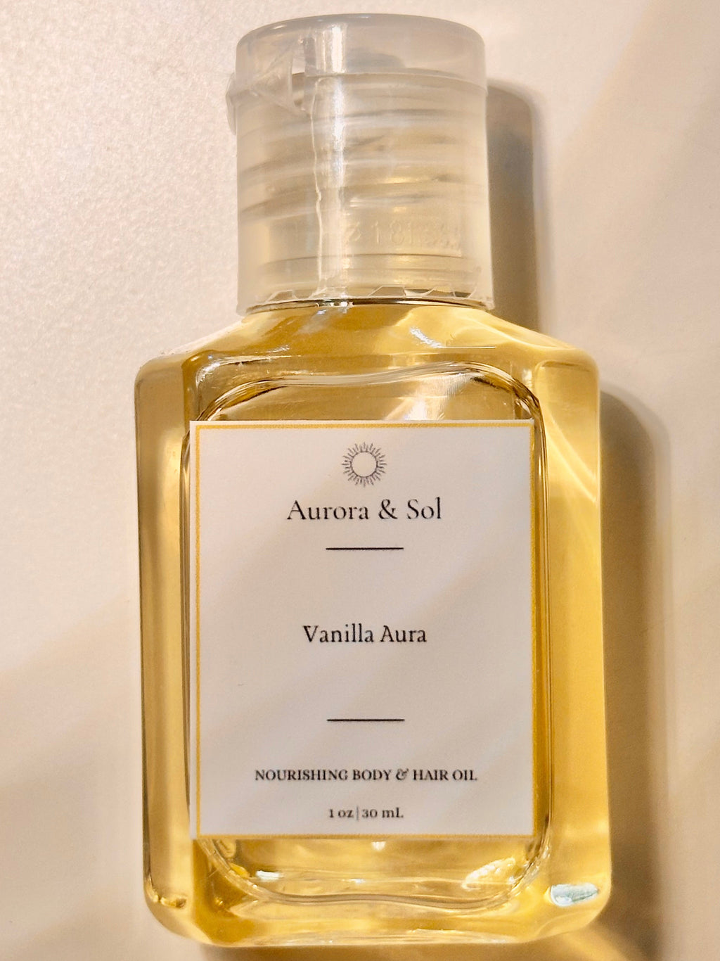 Aurora & Sol Vanilla Aura body and hair oil bottle on a beige background
