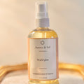Aurora & Sol Peach Glow body and hair oil bottle on a gold tray with a beige background