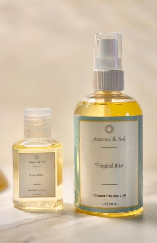 Two bottles of Aurora & Sol Tropical Bliss body oil on a light background