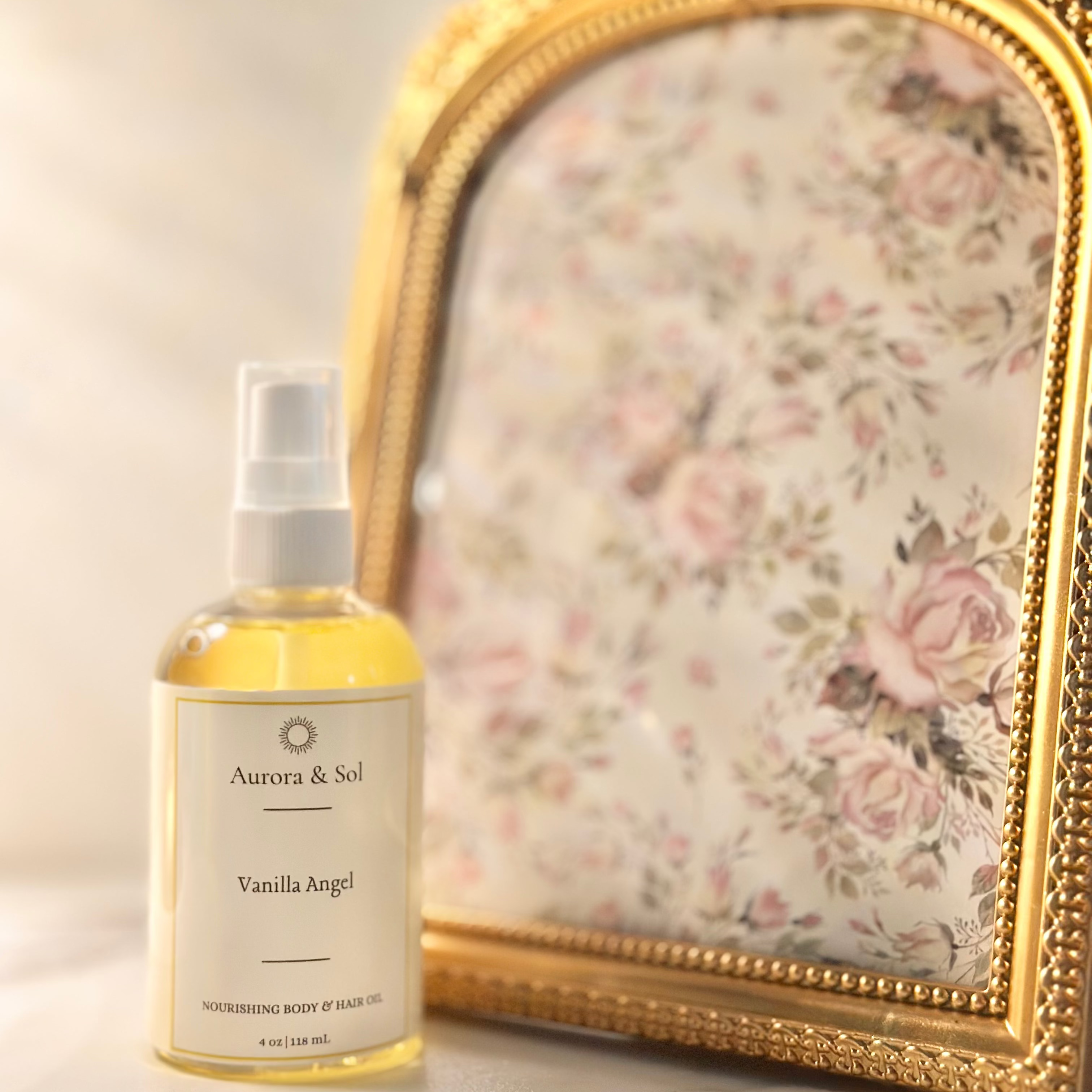A bottle of Aurora & Sol Vanilla hug! product next to a decorative gold frame with floral design.