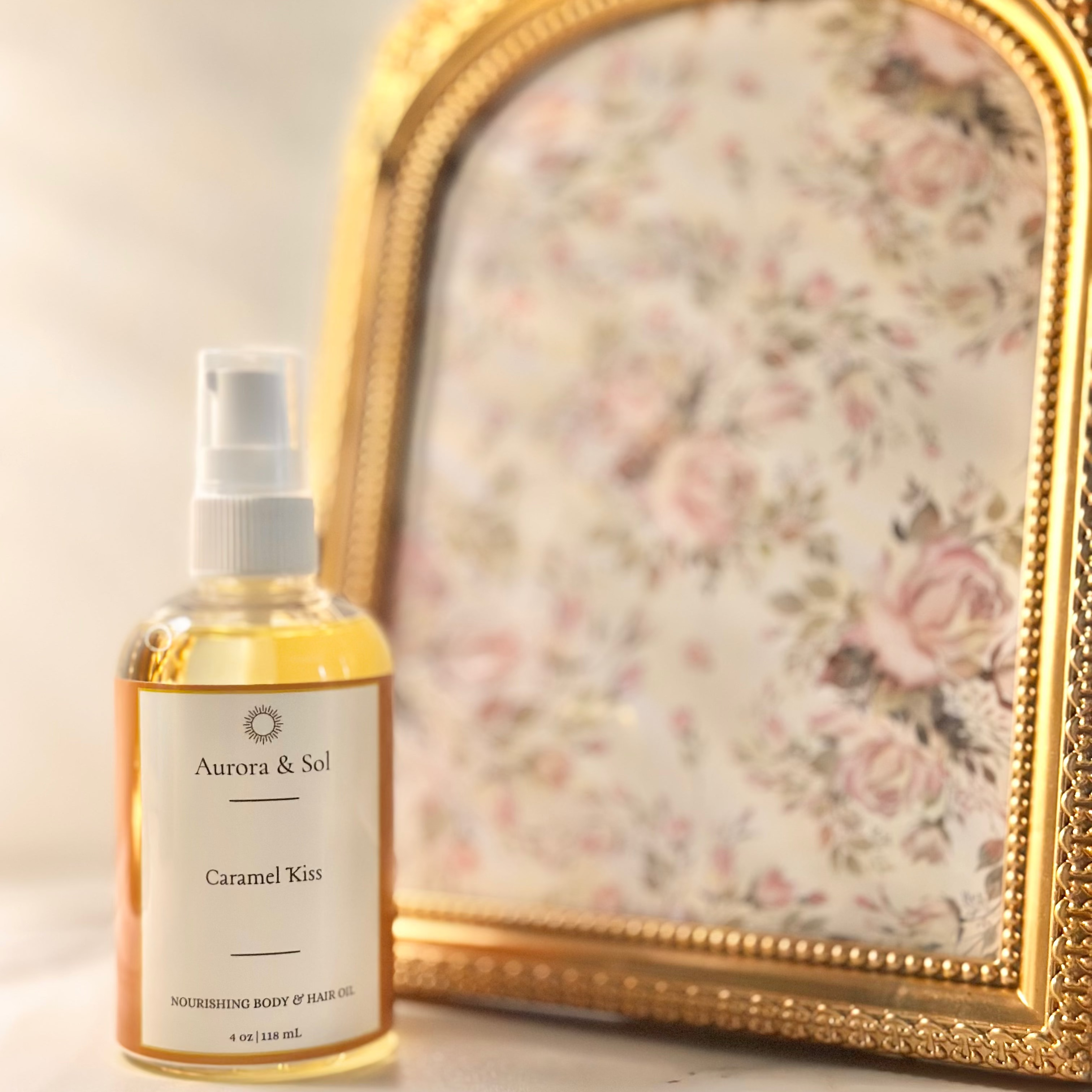 A bottle of 'Aurora & Sol Caramel Kim' product on a marble surface with a decorative gold frame in the background.