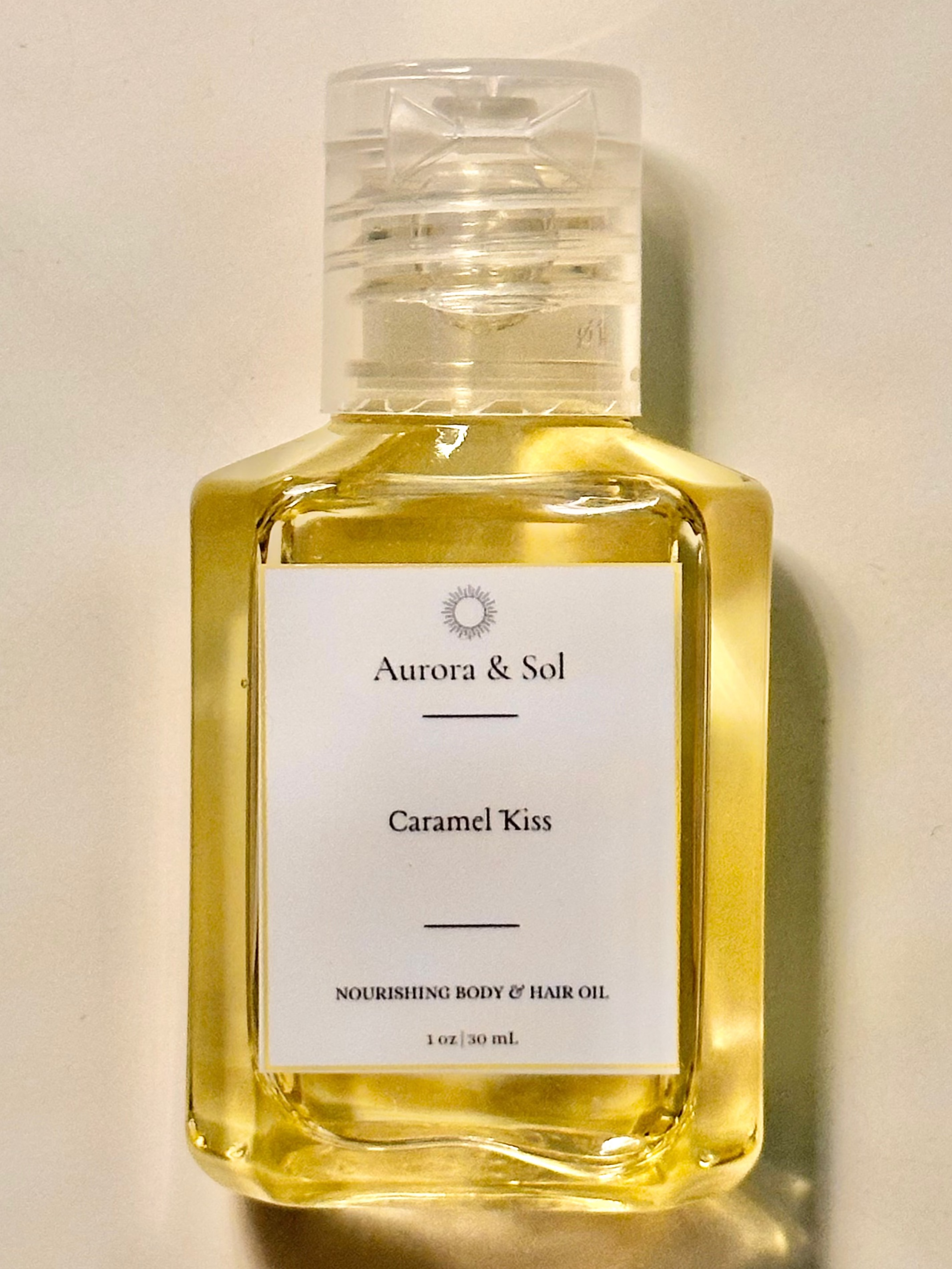 A bottle of Aurora & Sol Caramel Kiss oil on a light background