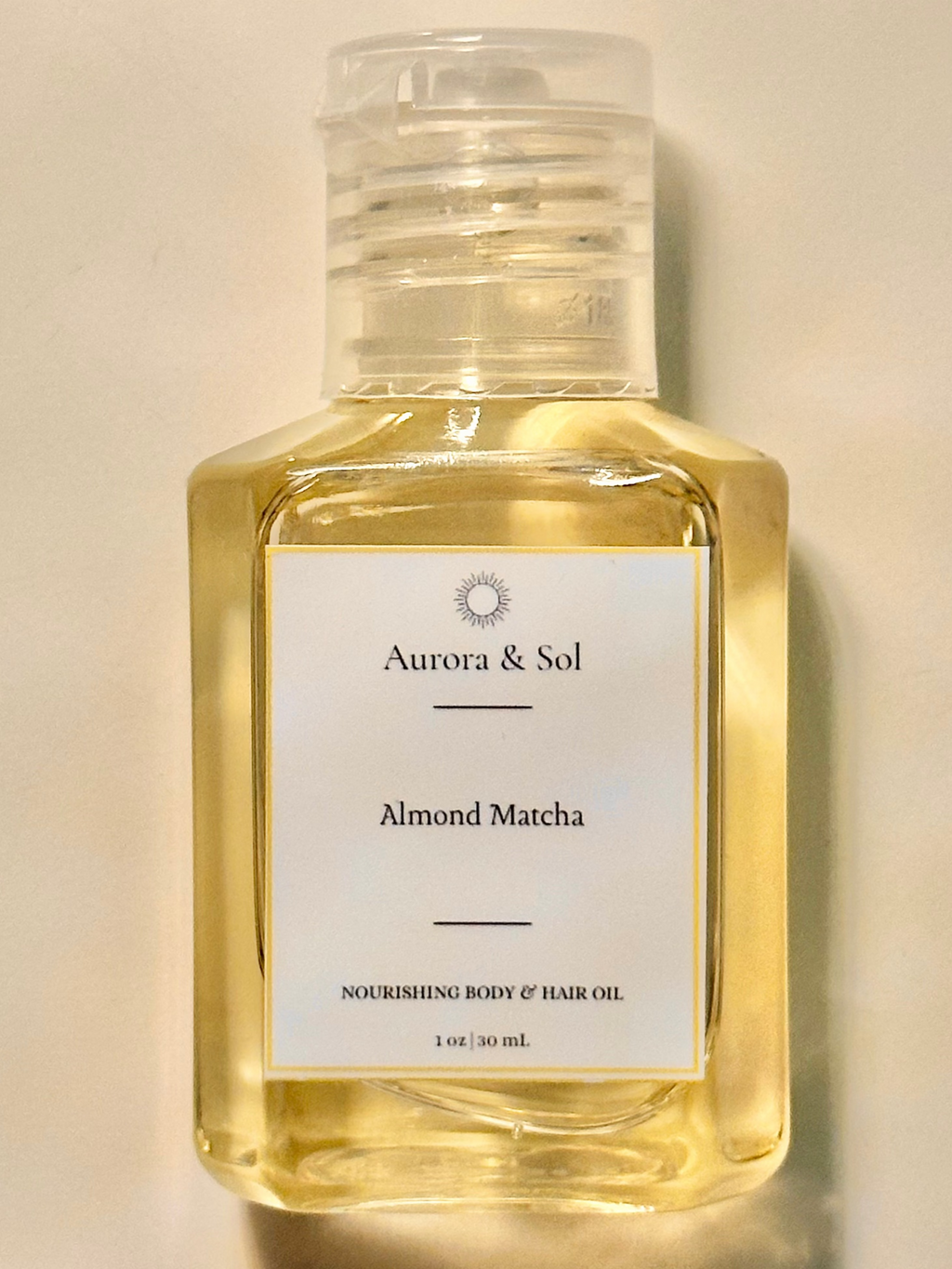 Aurora & Sol Almond Matcha body and hair oil bottle on a beige background