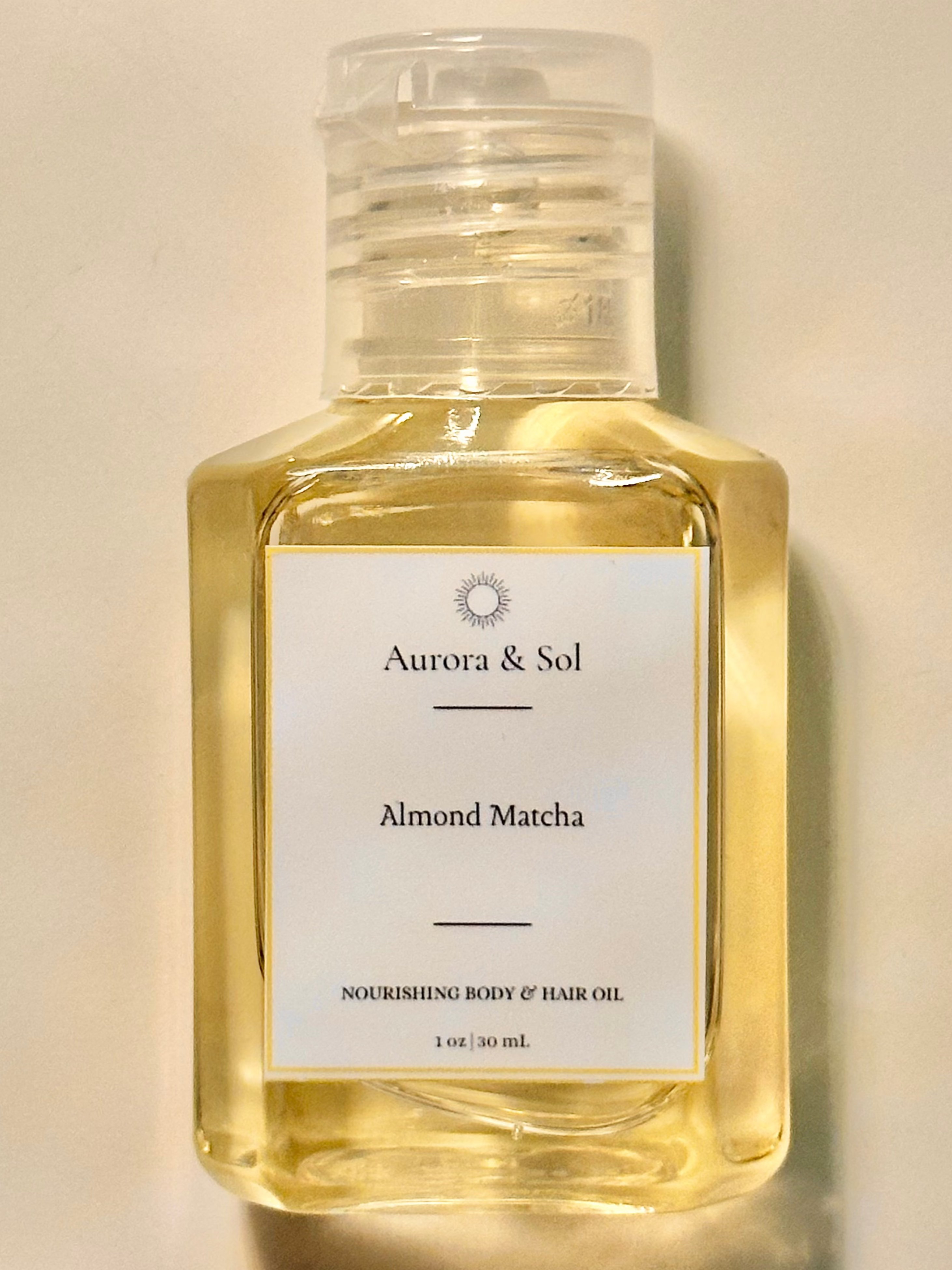 Aurora & Sol Almond Matcha body and hair oil bottle on a beige background