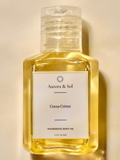 Aurora & Sol Cocoa Crème body oil bottle on a beige background